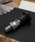 Zero Hassle Self Locking Indexing Pin With Heavy Round Pull Knob And Durable Steel Shaft on textured surface, showing steel shaft and knob.
