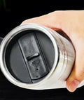 User holding the base of a Dual Voltage Car Kettle For 12V And 24V Vehicles With Insulated Stainless Steel Interior.
