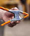 2 Inch Spring Clamp With Handle One Handed Clamping Tool Silver Orange Finish Quick Release Paddle Action for Woodworking and DIY Projects Workhorse Grip Control held in hand