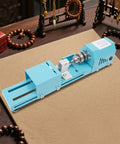 Super Compact Mini Wood Lathe Machine Featuring 96W Motor And Seven Adjustable Speeds Up To 9000Rpm For Precision Turning Punching Engraving Cutting Grinding Polishing Ideal Diy Projects With Lightweight Metal Body And Quick Change Chuck For Easy Setup positioned on a work surface with beads.
