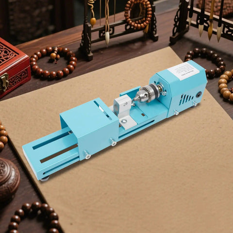 Super Compact Mini Wood Lathe Machine Featuring 96W Motor And Seven Adjustable Speeds Up To 9000Rpm For Precision Turning Punching Engraving Cutting Grinding Polishing Ideal Diy Projects With Lightweight Metal Body And Quick Change Chuck For Easy Setup positioned on a work surface with beads.