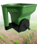 Handheld Garden Spreader For Seeds, Fertilizer And Salt Portable Manual Dispenser with Easy Grip in use over garden plot