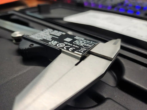 Close-up of a Top Notch 6 Inch Digital Caliper With 0.0005 Inch Resolution and 0.01 mm on black case, stainless steel vernier.