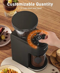 Game Changing Stainless Steel Conical Burr Coffee Grinder With Thirty Five Quick Grind Settings And One Touch Switch hands adjusting grind size dial.