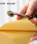 Using Two Pack Tracing Wheel and Pounce Wheel Set for Paper Perforation and Pattern Making on yellow paper in sewing project.