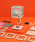 Levitating Lantern STEM Kit For Kids 9 Plus with wooden tensegrity base and building components on orange background