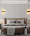 Gold Crystal Wall Sconce With Modern Vibe, Sleek Glass Rods And Stainless Steel Base on bedroom wall, set of two beside bed.