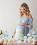 Pregnant woman in blue dress with Adventure Awaits Hot Air Balloon Cupcake Toppers 36 Piece Set Blue Clouds Party Picks
