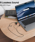 Clip-On MP3 Player With LED Light, 8GB Mini Music Player on table next to laptop for Sports, Gym, running and jogging