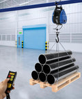 Heavy Duty Electric Chain Hoist, 1100 Lb Capacity With 1800 Watt Motor lifting black pipes from wooden pallet with remote control.