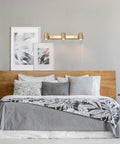 Three Light Plug-In Track Lighting in Matte Brass with Adjustable Heads above bed, wall-mounted, 15-foot cord visible