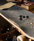 Heavy Duty M8 Locking Nuts For Skateboard Trucks 50 Piece Bombproof Iron Hardware Kit displayed on a skateboard deck during assembly.