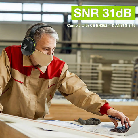 Man wearing Industrial Hearing Protection Earmuffs With 31 dB Noise Reduction in a workshop setting, using a computer.