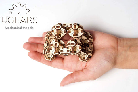 Hand holding Flexi Cubus Mechanical Anti Stress Puzzle Twist Spin And Reconfigure Eight Jointed Spheres Into Dynamic Cube Forms For Stress Relief Spatial Awareness Practice Brain Teasing Fun Dope On The Go Chill wooden puzzle