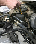 Mechanic checking engine oil next to Aluminum Brake Fluid Reservoir Drift Oil Tank For Cars High Performance Car Brake Oil Cup With Sleek Design Durable Aluminum Alloy Easy Install Keeps Brakes Quiet And Responsive For Street And Track Use in car engine compartment.