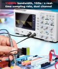Person using Dual Channel 110 MHz Digital Oscilloscope with 7 Inch TFT LCD Screen, Portable Pro Scope Kit on a circuit board