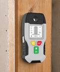 6-in-1 Stud Finder Wall Scanner Metal Detector LCD Display(Grey) on wooden wall, showing LCD interface and buttons.