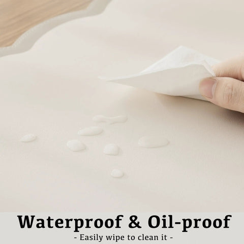 Close-up of Stylish Scallop Edge Desk Mat Crafted From Smooth Faux Leather Blend with drops of liquid for easy cleanup.