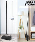 Manual Carpet Floor Sweeper With Dual Horsehair Brush Roll Quiet Non Electric Push Broom For Snagging Pet Hair And Lint No Sweat Home Cleaning Gear Black standing next to shelving.