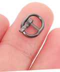 Close-up of a silver gunmetal buckle from the Mini Alloy Belt Buckles Set For Doll Clothes And Tiny Belts, 150 Pcs Small Single Prong Fasteners.