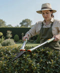 Gardener trimming hedges with Extendable Hedge Shears With No Ladder Needed 27 To 35 Inch Reach Wavy Stainless Steel Blades.