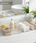 8 Pack Deep Drawer Organizers For Kitchens Closets And Bathrooms Super Solid Storage Bins holding toiletries on a bathroom countertop.