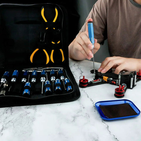 Person using All In One Tool Kit For Remote Control Cars Boats Drones Quadcopters And Helicopters with screwdrivers and pliers