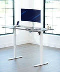 Upgrade Your Workspace With This Slick Dark Gray Standing Desk Measuring Sixty-Three By Thirty-Two Inches with monitor and keyboard.