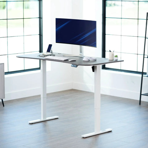 Upgrade Your Workspace With This Slick Dark Gray Standing Desk Measuring Sixty-Three By Thirty-Two Inches with monitor and keyboard.