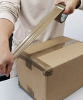 Person sealing box with Brown Packing Tape Refills, Heavy Duty Pack With Free Dispenser For Packaging, Shipping And Moving, 12 Rolls