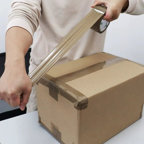 Person sealing box with Brown Packing Tape Refills, Heavy Duty Pack With Free Dispenser For Packaging, Shipping And Moving, 12 Rolls