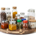 Rock Solid 20 Inch Wood Lazy Susan For Kitchen Counter Slick Acacia Turntable Serving Tray with spices and condiments organized on it.