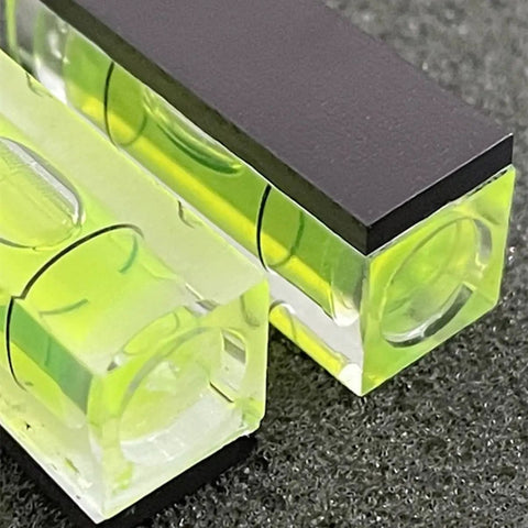 Close-up of two acrylic bubble levels from the Six Pack Mini Magnetic Bubble Level Kit with neon vials for precise measurements.