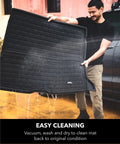 Man cleaning Kagu All Weather Cargo Liner for Tesla Model Y 5-Seat 2020-2026, showing easy wash and waterproof protection