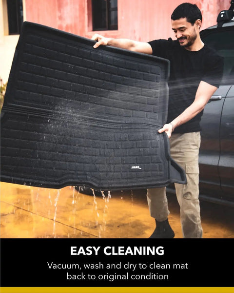 Man cleaning Kagu All Weather Cargo Liner for Tesla Model Y 5-Seat 2020-2026, showing easy wash and waterproof protection