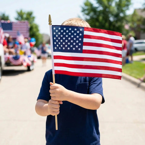 Child holding a 12 Pack 8x12 Inch American Flags On Sticks With Wooden Poles And Golden Spear Tops For Outdoor Use Memorial Day Fourth Of July Decor Perfect For Parades And Flag Waving in a parade setting.