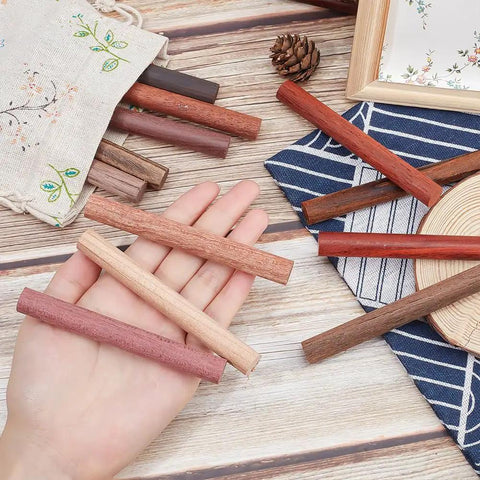Premium Grade Wood Pen Blanks And Dowel Rods 12 Assorted Colors Half Inch By Four Inch Turning Blocks on palm, assorted colors laid out.