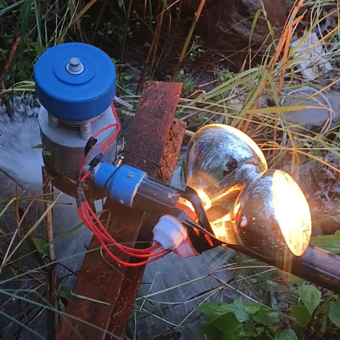 Beast 500W Micro Hydroelectric Turbine Generator for Outdoors setup with glowing bulbs, in a natural setting.
