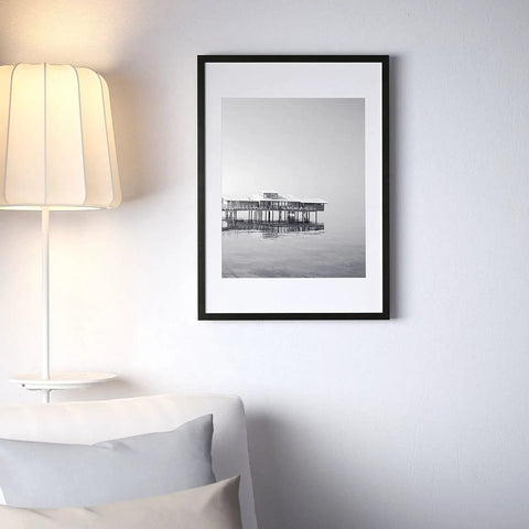 Black and white framed photo on wall with couch and lamp, demonstrating Peel And Stick Molding And Wall Trim Set For DIY Home Decor On Cabinets Doors Mirrors And Frames Self Adhesive No Mess Easy Install Non Toxic 16.4 Ft Long By 0.8 In Wide.