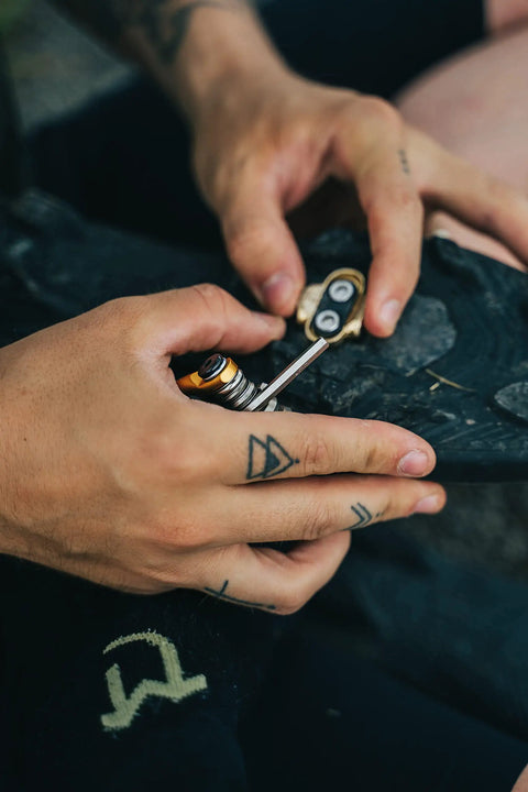 Hands using All-In-One Bike Multitool M19 Matte Black With Hex Wrenches on a bicycle pedal for repair.