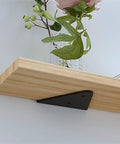 Heavy Duty Triangle Shelf Brackets For Wall Mount Floating Corner Supports in use holding a wooden plank with plants.