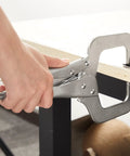 Person using Four Piece Locking C Clamp Set With Fixed And Swivel Pads, 6 Inch Dual Pad, 9 Inch And 11 Inch Welding Clamps on a table