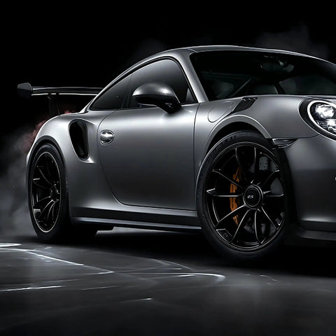 Pro Grade Black Wheel Rim Protectors Four Pack Universal Tire Edge Guards on black alloy rims of a sleek sports car.