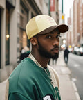 Man wearing casual attire and a beige cap on a city street, not Womens Washed Cotton Dad Hat With Adjustable Strap Anti Sweat Band Lightweight.