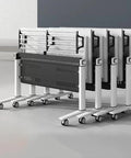 No Fuss Slick Heavy Duty Foldable Mobile Training Table With Secure Lock Swivel Rollers and Tall Privacy Screen stacked neatly for storage.