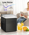 Compact Countertop Ice Maker With One Touch Auto Clean System That Skips The Grunt Work Cools Down Fast And Spits Out Crisp Crystal Clear Ice next to a drink on a table.