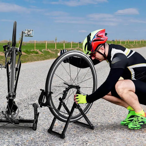 Cyclist using Foldable Bike Wheel Truing Stand With Spoke Wrench For Home Mechanics Aluminum Alloy Frame Front Three Point Nine Inch And Rear Five Point Three Inch Compatibility Includes Ruler Knob Adjustments Easy Portable Wheel Maintenance Kit on road