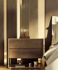 Modern bedroom with wooden nightstand and decorative lamp beside a neatly made bed.