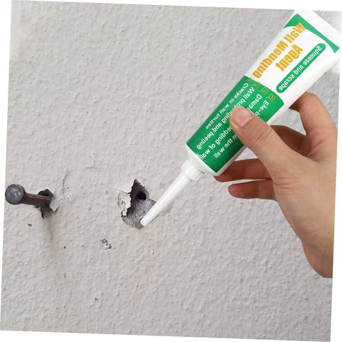 Wall Repair Paste Set With Self Adhesive Mending Cream, Scraper And Spout For Quick Crack Fix being applied to wall hole