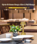 Cordless Gold Battery Operated Table Lamp For Dining Ambience on restaurant table with dishes and plant